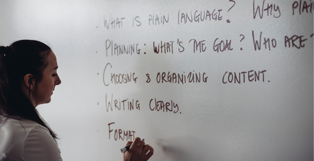 Suzanne Boyd writing on a white board about plain language