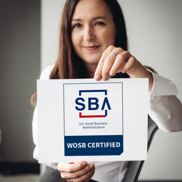 Photo of Anthro-Tech founder, Suzanne Boyd, holding an SBA - WOSB certificate.